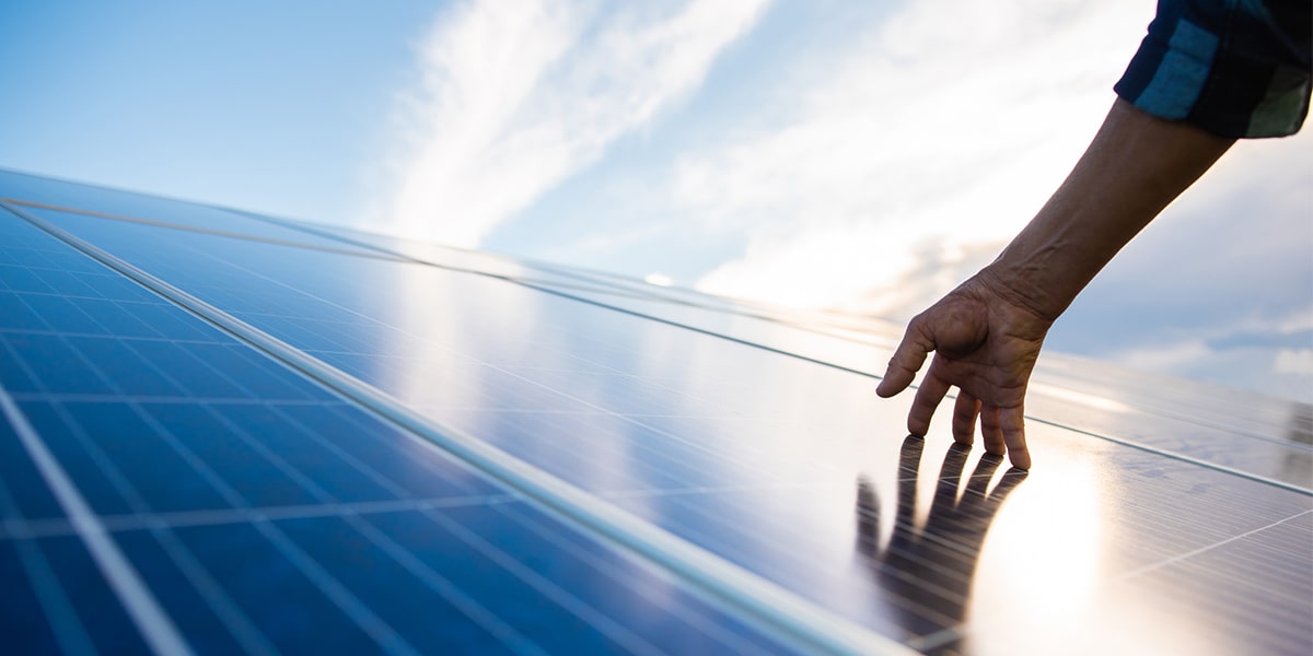 hand touching solar panels